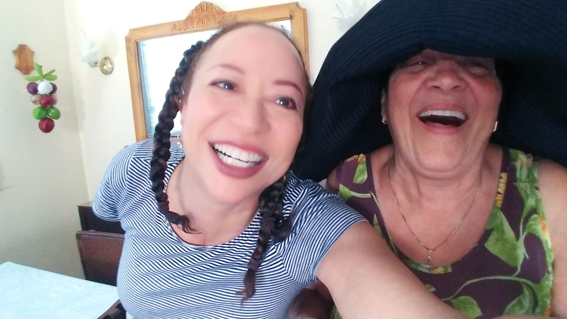 Allison laughing with a woman wearing a wide black hat in Havana