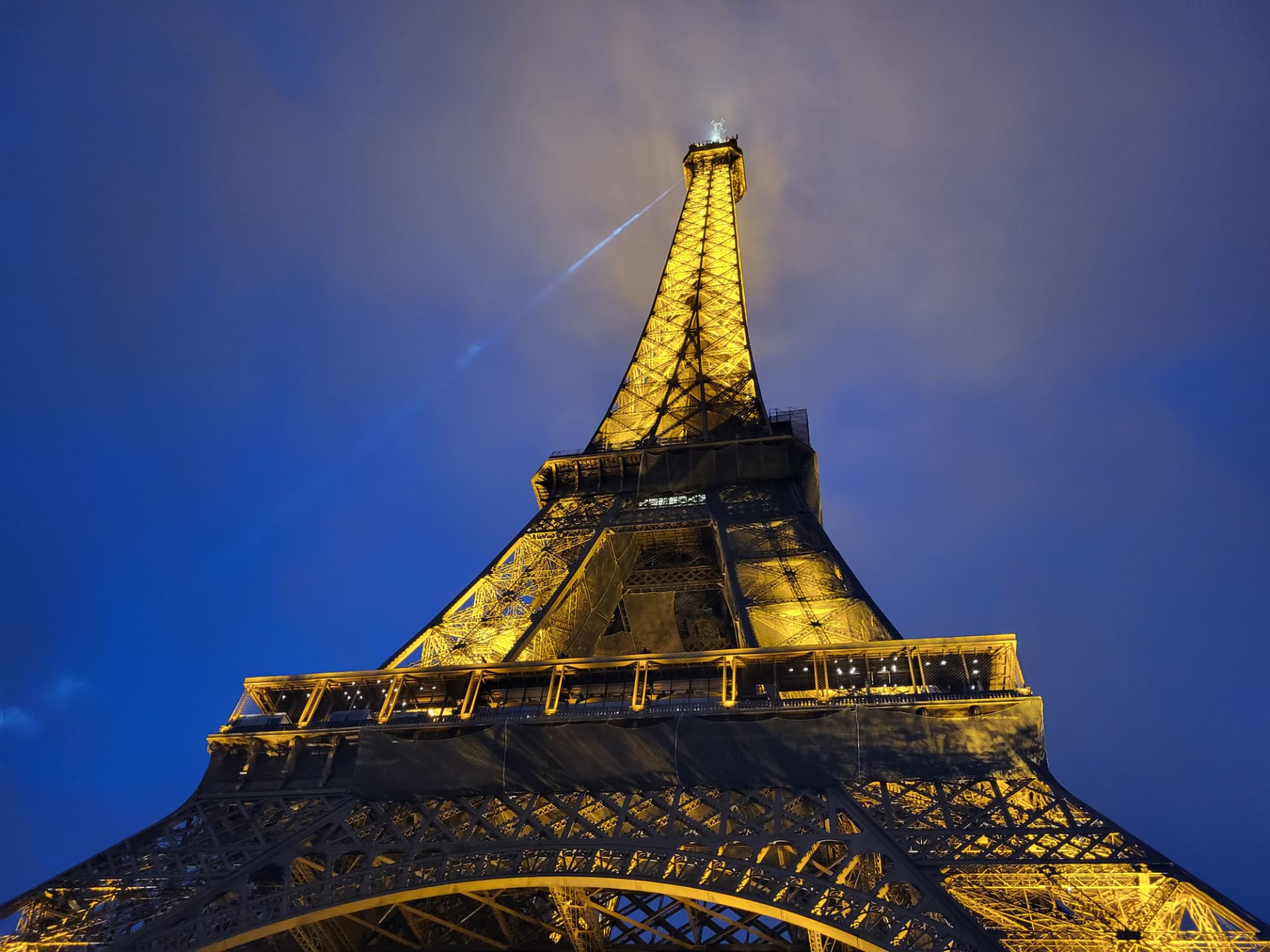 The illuminated Eiffel Tower rising into a deep blue evening sky