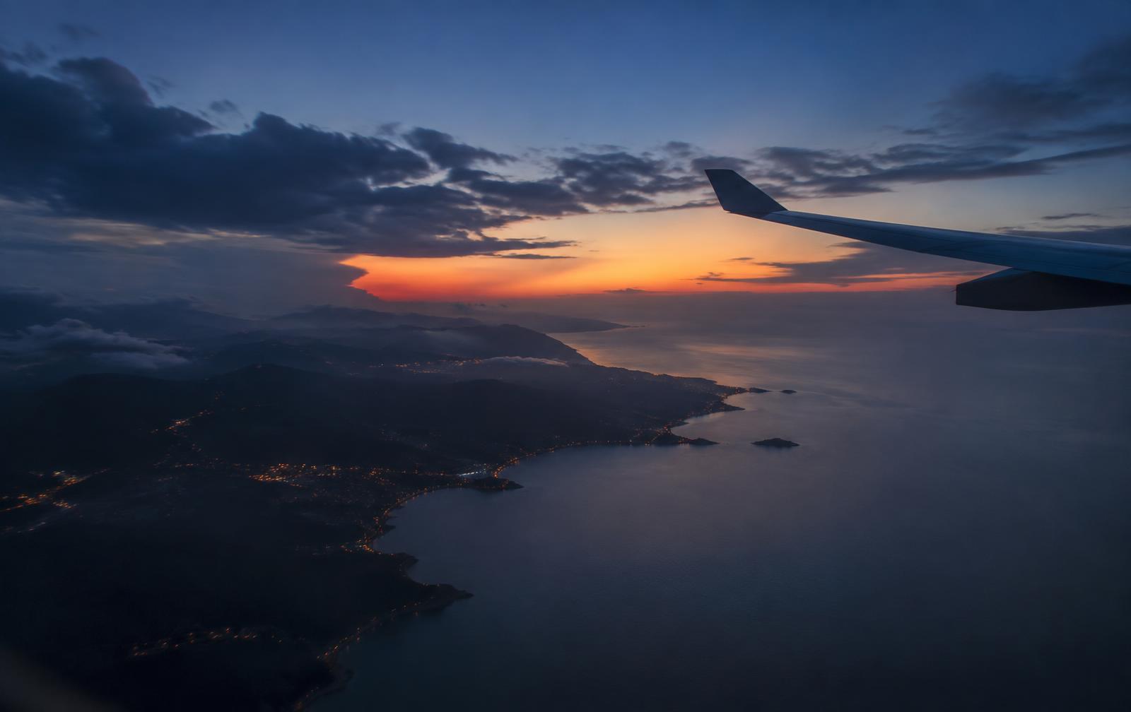 View of a coastline at dusk from an airplane window
